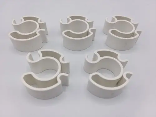 Sechs weiße Klemmteile in leichter plastischer Form, verwendet zur Befestigung oder Lagerung, bereit für Anwendungen, eventuell von Remeha.